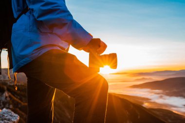 Erkek bir fotoğrafçı, gün doğumunda ya da günbatımı macera yolculuğunda dağın tepesinde dinleniyor. - Evet. Yüksek kalite fotoğraf