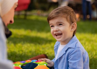 Anne ve oğlu bahçede bir oyuncakla oynuyorlar. Birlikte eğleniyorlar. Yüksek kalite fotoğraf