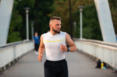 Şehir köprüsünde koşan ya da koşan genç bir atletik. Aktif ve sağlıklı bir yaşam tarzı var. Yüksek kalite fotoğraf
