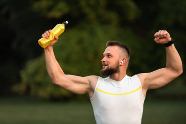 Başarılı bir çalışmadan sonra formda genç bir adam yumruğunu kaldırıyor. Spor zaferi kavramı, zafer. Yüksek kalite fotoğraf