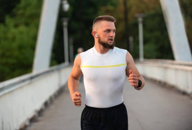 Şehir köprüsünde koşan ya da koşan genç bir atletik. Aktif ve sağlıklı bir yaşam tarzı var. Yüksek kalite fotoğraf