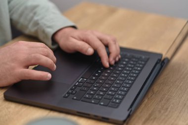 Bir iş adamının elleri ahşap masa masasında dizüstü bilgisayarda çalışırken ve daktilo yazarken yakın plan görüntüsü. Yüksek kalite fotoğraf