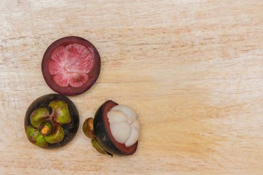 Queen of fruit. Mangosteens on the wooden plate.