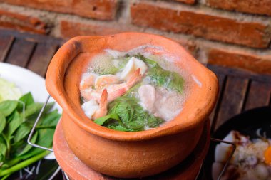 Hot pot thai style. Hot pot with clear soup in the clay cooking pot.