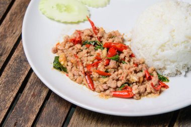 Ahşap arka planda kıymalı Tayland fesleğenini karıştır. Tayland 'ın en sevdiği yemek 