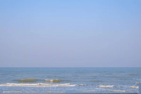 Gün batımında mavi gökyüzü ile deniz ve dalga.