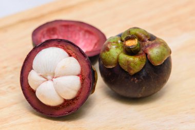 Queen of fruit. Mangosteens on the wooden plate.