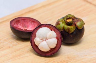 Queen of fruit. Mangosteens on the wooden plate.