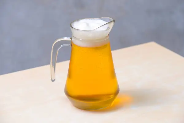 Bira cam cereyanda bira sürahisi ahşap masada..