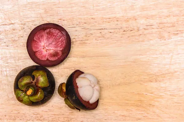 Queen of fruit. Mangosteens on the wooden plate.