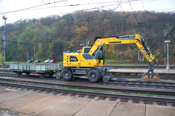 stock image A yellow liebherr bagger 922 Rail at work close to platform. Czech Republic.