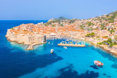 Dubrovnik 'in Eski Şehir' inin canlı bir drone fotoğrafı. Eski duvarlar, kırmızı çatılar ve tarihi mimari. Hepsi de Adriyatik Denizi ile çevrili ve canlı yaz tonlarıyla zenginleştirilmiş..