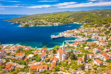 Hırvatistan 'ın Bra Adası' ndaki pitoresk bir kıyı kasabası olan Sumartin 'in insansız hava aracı görüntüsü. Sahne, Adriyatik Denizi 'nin büyüleyici limanı, geleneksel taş evleri ve bereketli yeşillik ve Akdeniz güzellikleriyle çevrili kristal berrak sularını yakalıyor..