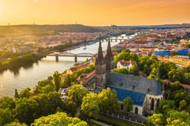 Çek Cumhuriyeti Prag 'daki Vyehrad Kalesi ve St. Peter Kilisesi' nin günbatımında Gotik mimari ve Vltava Nehri üzerindeki tarihi kaleyi gözler önüne seren çarpıcı bir hava manzarası.