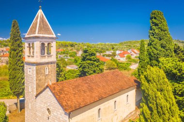 Hırvatistan 'ın Solta Adası' ndaki Donje Selo kentindeki St. Martin Piskopos Kilisesi 'nin çarpıcı hava manzarası, geleneksel taş tasarımı, huzurlu köy düzeni ve güzel Akdeniz çevresiyle birlikte