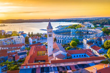 Günbatımında Hırvatistan 'daki Pula Arena' nın nefes kesici hava manzarası, tarihi şehir ve çarpıcı Adriyatik kıyı şeridiyle çevrili antik Roma amfitiyatrosunu altın ışıkla aydınlatıyor.