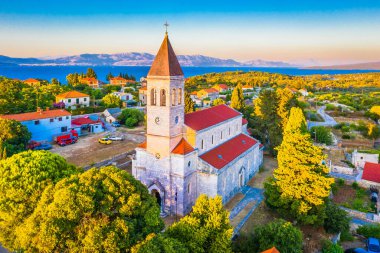 Hırvatistan 'ın Solta Adası' ndaki Grohote Kilisesi 'nin nefes kesici manzarası, tarihi taş mimarisini ve bereketli doğayla çevrili büyüleyici Akdeniz köyünü vurguluyor.