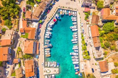 Hırvatistan 'ın Solta Adası' ndaki Stomorska marinasının nefes kesici yukarıdan aşağıya hava görüntüsü, düzenli düzenlenmiş teknelerin sergilenmesi, bu Akdeniz yat cennetinin özünü yansıtıyor.