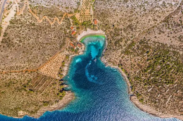 Hırvatistan 'ın Hvar Adası' ndaki Dubovica Sahili 'nin tepeden aşağı havadan görünüşü turkuvaz Adriyatik suları ve altın kıyı şeridi ile gösterilerek Avrupa' nın en güzel gizli plajlarından biri haline getirildi.