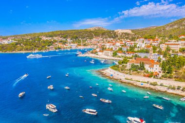 Hırvatistan 'ın Hvar Limanı' nın nefes kesen manzarası, turizm sezonunun zirvesindeki yatlar ve teknelerle dolup taşan tarihi mimari, canlı liman ve kristal berraklığında Adriyatik Denizi ile çevrili