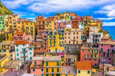 İtalya 'nın Manarola kentindeki renkli evlerin Ligurian Denizi' ne bakan sarp kayalıklara tutunup büyüleyici bir atmosfer yarattığı canlı ve geleneksel mimarinin çarpıcı bir görüntüsü.