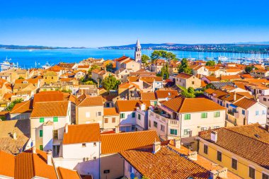 Hırvatistan 'ın Adriyatik kıyısındaki geleneksel bir balıkçı kasabası olan Biograd na Moru' nun büyüleyici hava manzarası marinasını, taş evlerini, eski kasaba merkezini ve çevreleyen denizin canlı mavi sularını gösteriyor.