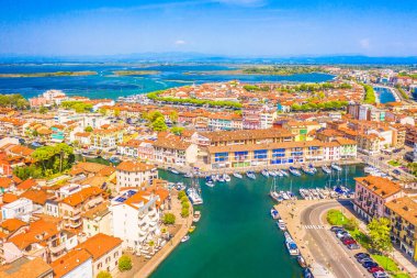 Porto Vecchio ve İtalya 'nın Friuli-Venezia Giulia kentindeki tarihi sahil kenti Grado' nun büyüleyici bir hava görüntüsü, büyüleyici bir liman, kırmızı başlıklı çatılar ve çevreleyen kıyı şeridi yer alıyor.