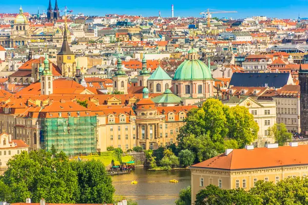 Vltava Nehri 'nin ön planda aktığı Prag, Çek Cumhuriyeti' nin klasik manzara manzarası, tarihi köprüler ve arka planda şehrin ikonik mimari gökyüzü çizgisi yer alıyor.