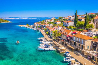 Hırvatistan 'ın Solta Adası' ndaki büyüleyici bir kıyı kasabası olan Stomorska 'nın hava manzarasında kırmızı çatılı evleri, turkuaz Adriyatik suları ve huzurlu Akdeniz atmosferi sergileniyor