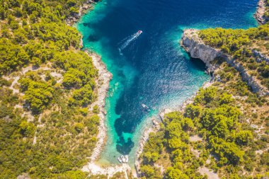 Hırvatistan 'ın Solta Adası' nın güney tarafındaki Tatinja Sahili 'nin yukarıdan aşağıya bakan manzarası, eşsiz kıvrımlı kıyı şeridi, turkuaz suları, kayalık çevresi ve el değmemiş manzarasını ortaya çıkarıyor.