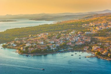 Hırvatistan 'ın Sibenik kenti yakınlarındaki Grebastica kıyı köyünün hava manzarasında derin bir körfez, Adriyatik suları turkuaz ve Dalmaçya bölgesinde bereketli Akdeniz çevreleri yer alıyor.