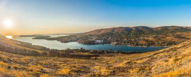 Hırvatistan 'ın Sibenik kenti yakınlarındaki Grebastica' nın panoramik hava manzarası, gün batımında körfezi aydınlatan sıcak altın ışıkla ve manzaralı Dalmaçya kıyı şeridi boyunca uzanan Adriyatik sularını sükunetle yakaladı.