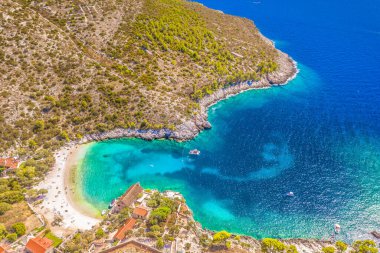 Hırvatistan 'ın Hvar Adası' ndaki Dubovica Sahili 'nin hava manzarasında dramatik kayalık kıyı şeridi, kristal berrak turkuaz suları ve dokunulmamış Akdeniz doğasıyla çevrili tenha koyları sergileniyor.