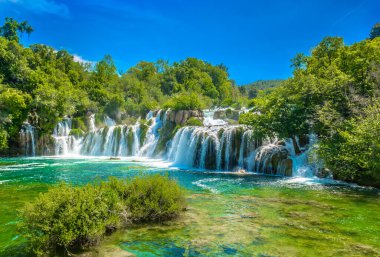 Hırvatistan 'ın Krka Nehri ulusal parkındaki Skradinski Buk rıhtımının manzaralı manzarası, zümrüt şelaleleri, manzaralı kırsal bölgeleri ve yemyeşil yeşillikleriyle tanınan ünlü doğal kaçışı