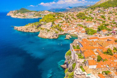 Dubrovnik kıyı şeridinin insansız hava aracı fotoğrafı engebeli uçurumları, turkuaz Adriyatik Denizi 'ni, dağınık koyları, yemyeşil ve günışığı kıyı şeridi boyunca tarihi taş mimariyi gösteriyor.