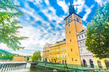 Prag 'ın tarihi merkezi, şık binaları, nehir kenarındaki geçitleri, Vltava Nehri boyunca uzanan ağaçları ve tekneleri canlı bir Avrupa başkentinde parlak bir gökyüzünün altında gösteriyor.