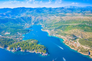 Dubrovnik yakınlarındaki Zaton 'un açık mavi Adriyatik suları, kıyı evleri, yeşil tepeler ve parlak gökyüzü altındaki huzurlu Akdeniz manzarasıyla dolu koydaki görüntüsü.