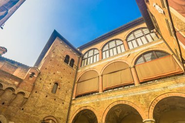 Photo of a typical building facade in Siena old town showing medieval stone and brick architecture, rustic windows with shutters and authentic Tuscan atmosphere in Italy