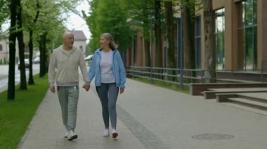 Sokakta yürürken el ele tutuşan olgun bir çift. Aşk ve iletişim kavramı.