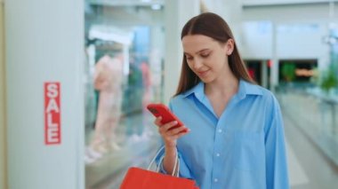 Onu kağıt torbada tutan mutlu müşteri. Alışveriş çantasını taşıyan, telefonunu kullanan, mesaj atan bir kadın. Alışverişten sonra arkadaşlarla akıllı telefon sohbeti yapan bir kadın.