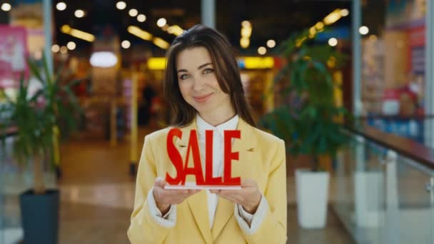 商店打折和购物 穿着正装的年轻女人的画像 指着销售题词和微笑 推荐低价商品 — 图库视频影像
