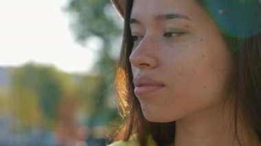 Gülümseyen Asyalı kadının portresi, yerel gölün yanında duran şapkalı ve kameraya bakan. Sevimli bayan doğrudan kameraya bakıyor. Halk konsepti