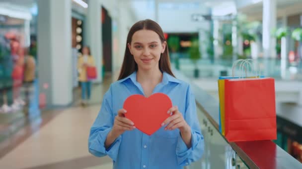 情人节 女店员形象地展示了她在商场里过情人节的心 白种人女人 红纸红心 准备迎接情人节 — 图库视频影像