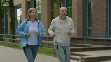 Sokakta kulaklık takıp müzik dinleyen olgun bir çift. Spor ve sağlıklı yaşam tarzı insanlar konsepti