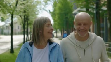 Yetişkin bir çift sokakta koşuyor kulaklık takıyor ve antrenman sırasında müzik dinliyor. Spor, ilişki ve sağlıklı yaşam tarzı kavramı