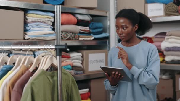 Brunette Femme Debout Entrepôt Tout Tapant Tablette Comptant Les Vêtements — Video