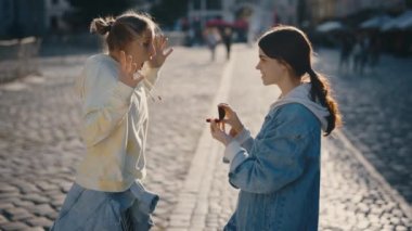 Genç lezbiyen şehir merkezinde sevgili kadınına sürpriz bir evlilik teklifi yapıyor. Kadın partneri duygusal olarak kabul ediyor ve sevgiyle sarılıyor.