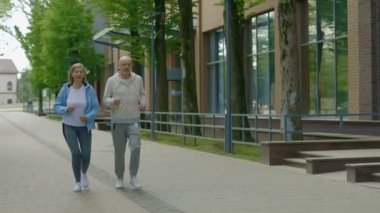 Aktif kıdemli karı koca, kardiyo egzersizi yapıp dışarıda birlikte koşuyorlar. Spor ve sağlıklı yaşam tarzı kavramı. Gençlik Yaşlanma