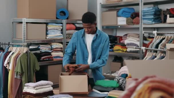 Mehrrassige Männliche Arbeiter Sortieren Kleidung Und Legen Sie Die Schrankbox — Stockvideo