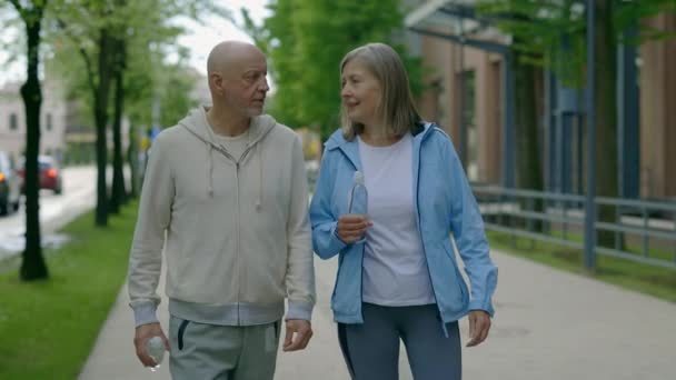 Yetişkin Bir Çift Elinde Şişesiyle Koştuktan Sonra Yürüyorlar Spor Iletişim — Stok video